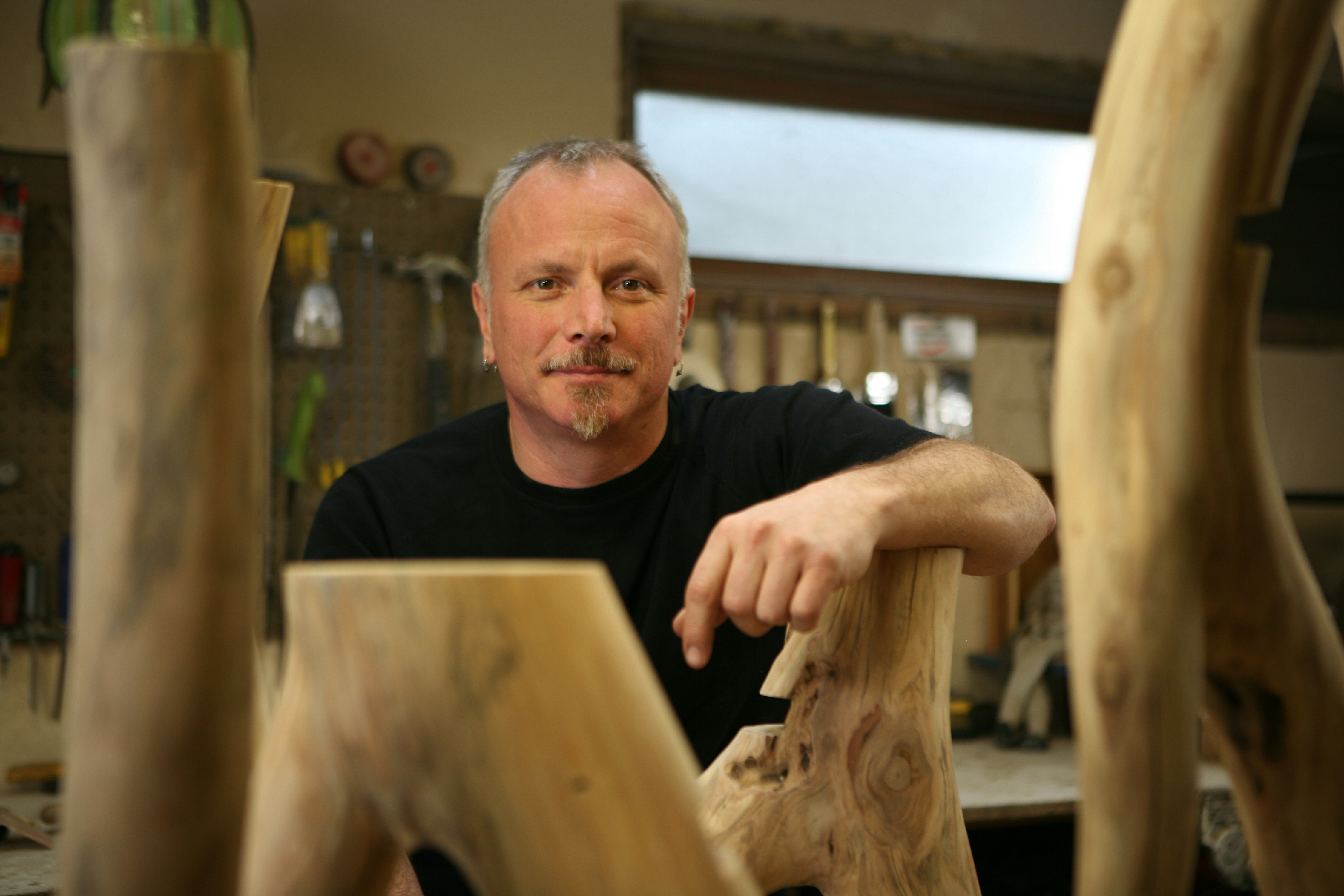 Greg Martodam in his workshop, surrounded by natural wood pieces